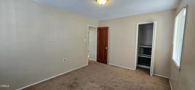 unfurnished bedroom featuring light carpet