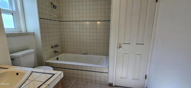 full bathroom with tiled shower / bath, toilet, and sink