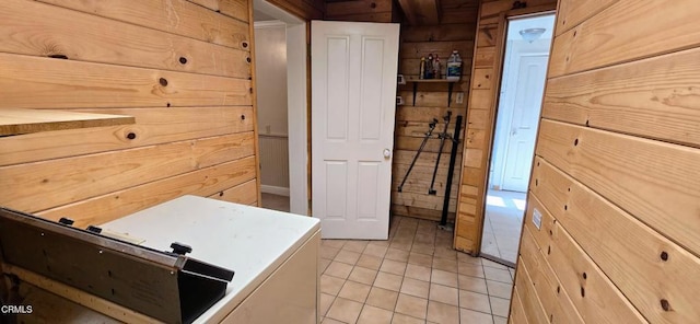 interior space with wooden walls, light brown cabinetry, and light tile patterned floors