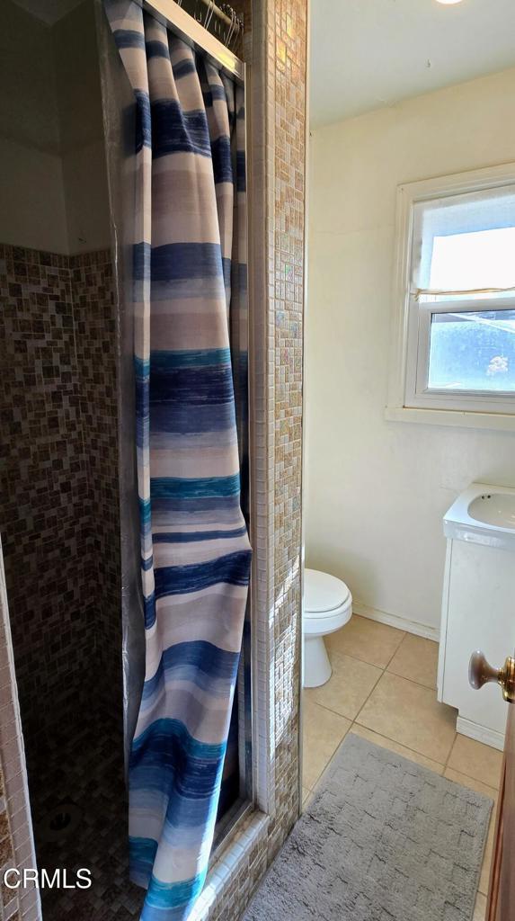 bathroom featuring vanity, toilet, tile patterned flooring, and a shower with shower curtain