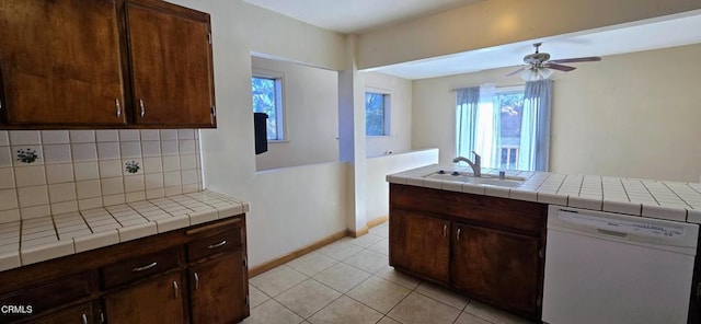 kitchen with dishwasher, sink, and tile counters