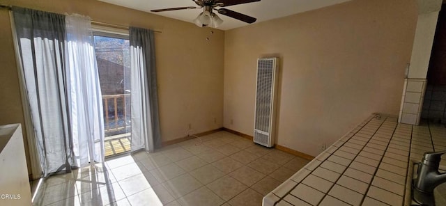 tiled spare room with ceiling fan