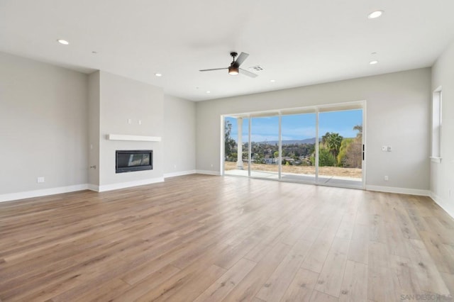 unfurnished living room featuring ceiling fan and light hardwood / wood-style floors