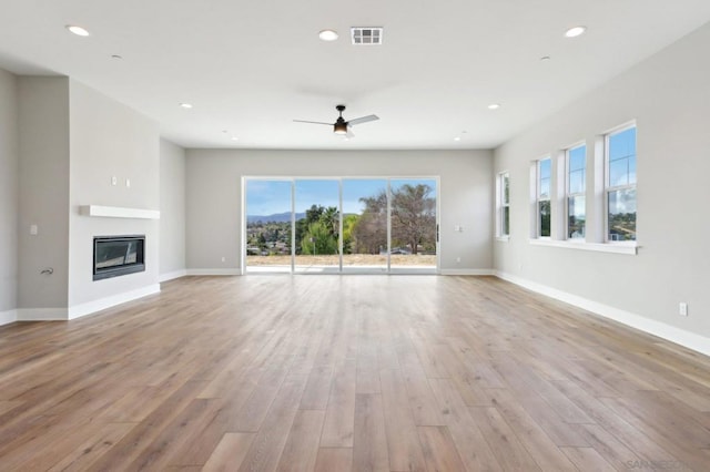 unfurnished living room featuring ceiling fan and light hardwood / wood-style flooring