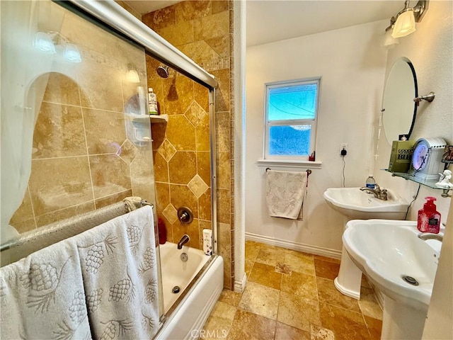 bathroom featuring dual sinks and enclosed tub / shower combo