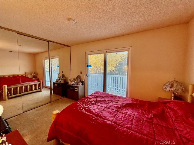 bedroom featuring carpet flooring, access to outside, and a textured ceiling