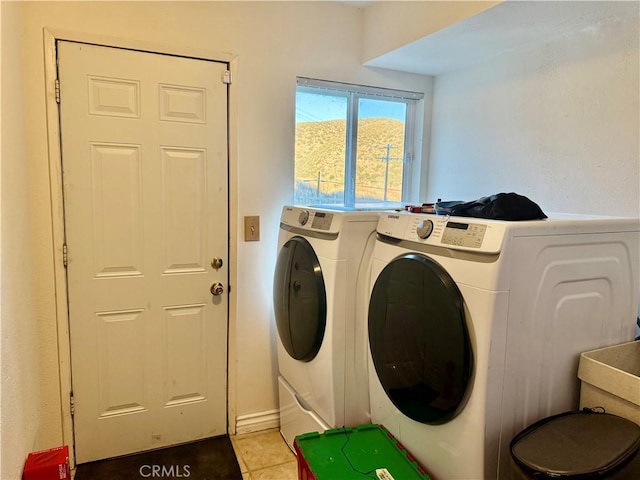 washroom with light tile patterned floors and washer and dryer