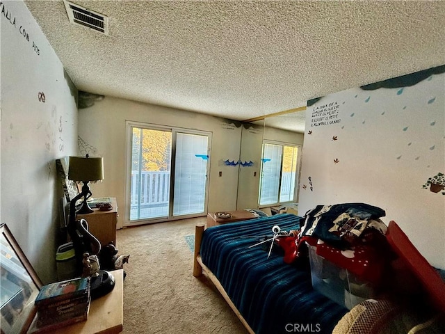 carpeted bedroom with a textured ceiling and access to outside