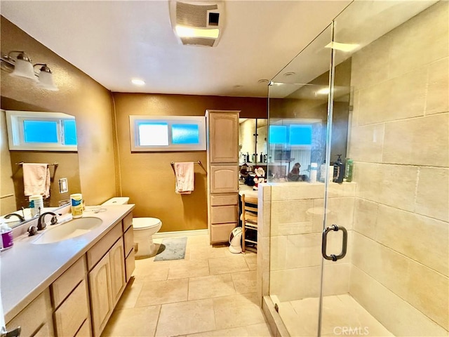 bathroom with vanity, tile patterned floors, a shower with door, and toilet