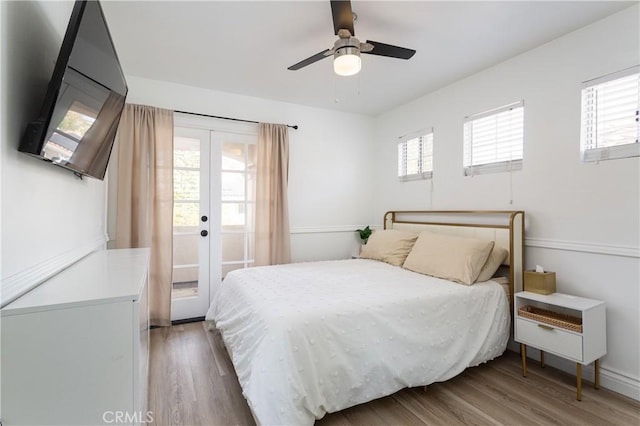 bedroom with multiple windows, hardwood / wood-style floors, access to outside, and french doors