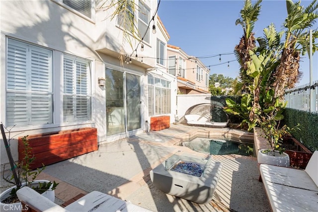 view of patio with a fenced in pool and a fire pit