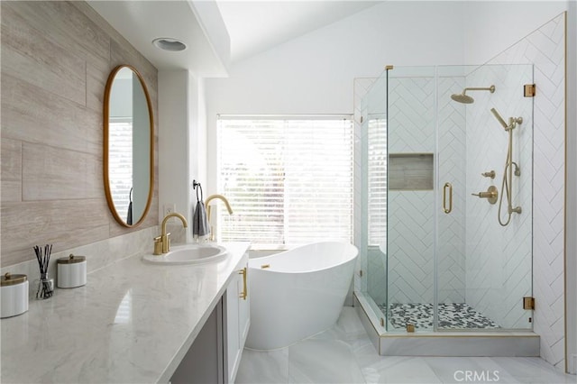 bathroom featuring vaulted ceiling, separate shower and tub, and vanity