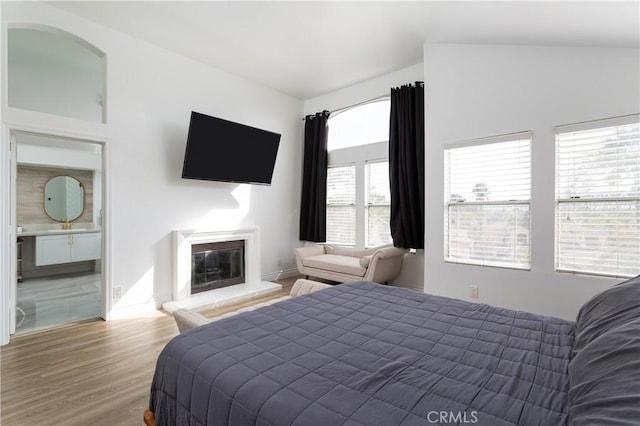 bedroom featuring hardwood / wood-style flooring and connected bathroom