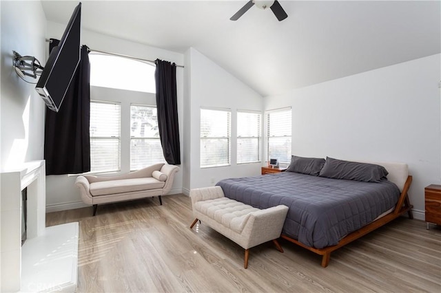 bedroom with vaulted ceiling, ceiling fan, and light hardwood / wood-style flooring