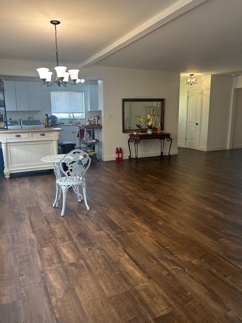 dining space with beamed ceiling, dark hardwood / wood-style flooring, and a chandelier