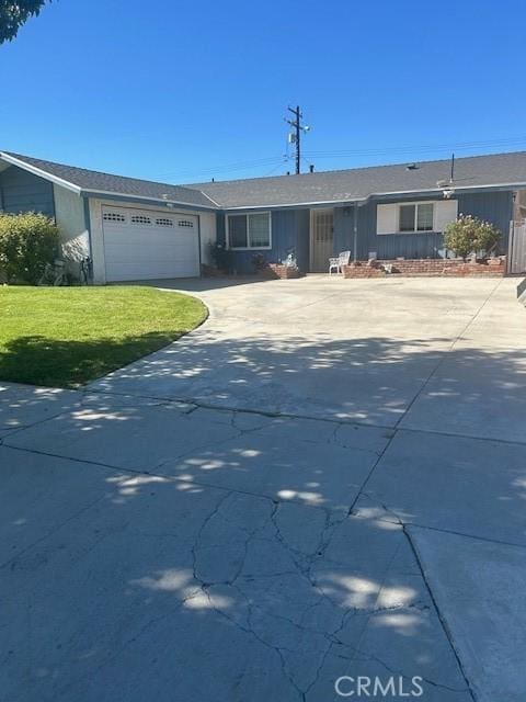 ranch-style home with a garage and a front lawn