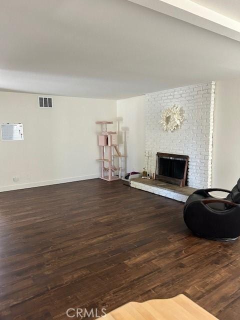 living room with dark wood-type flooring and a fireplace