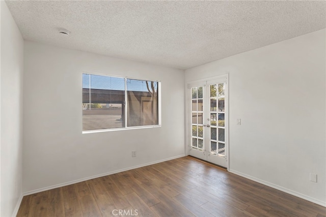 unfurnished room with dark wood-type flooring, french doors, and a textured ceiling