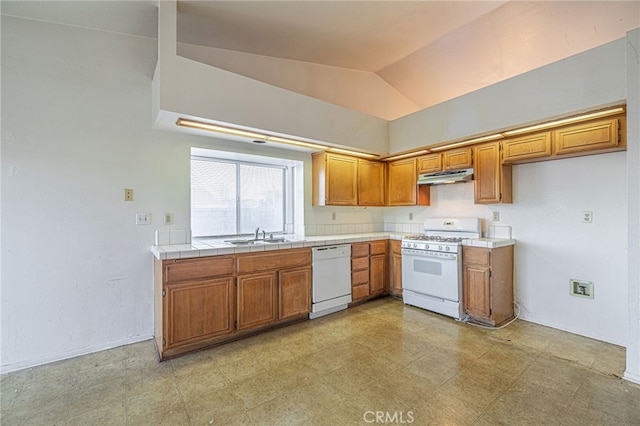 kitchen featuring lofted ceiling, sink, white appliances, and tile countertops