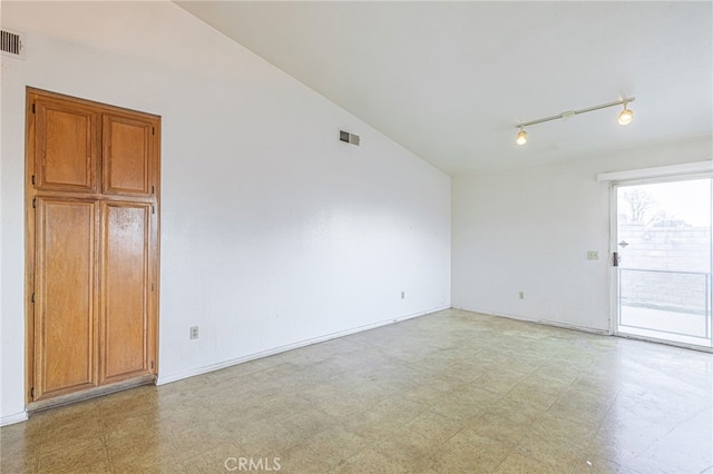 empty room with lofted ceiling and rail lighting