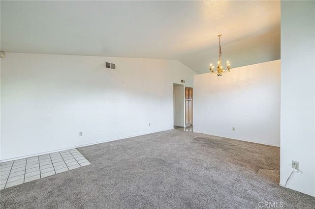 carpeted spare room featuring a chandelier and vaulted ceiling