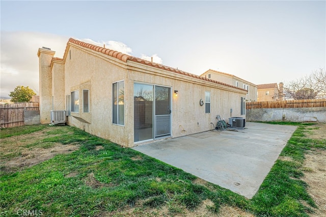 rear view of house with central AC, a yard, and a patio area