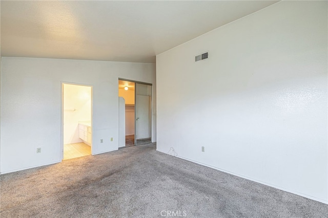 empty room with vaulted ceiling and light carpet