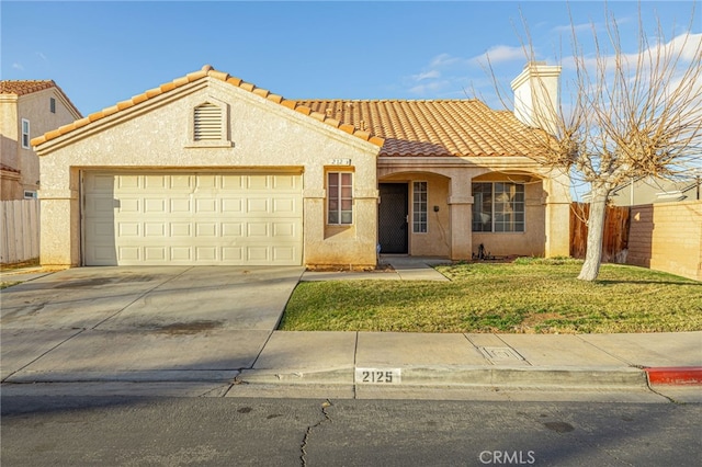 mediterranean / spanish-style house with a garage and a front yard