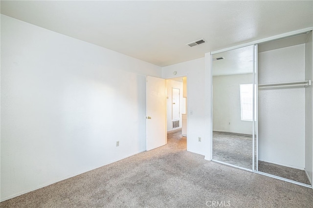 unfurnished bedroom featuring carpet flooring and a closet