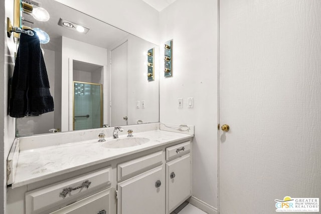 bathroom with vanity and a shower with shower door