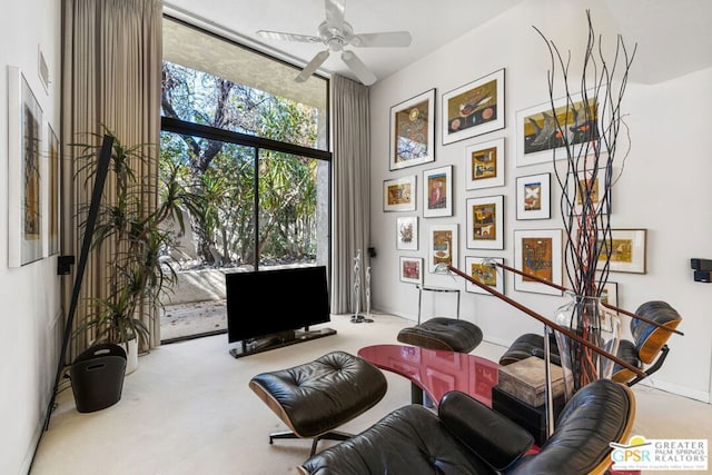 living area with floor to ceiling windows, carpet floors, and ceiling fan