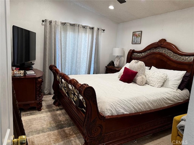 bedroom with vaulted ceiling and a textured ceiling