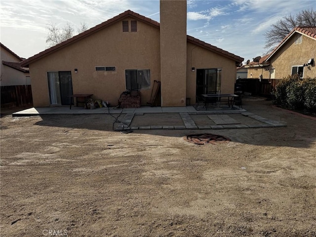 3319 Kellie Ave, Rosamond, CA 93560 - back of house featuring stucco siding, a patio, a tiled roof, and a chimney