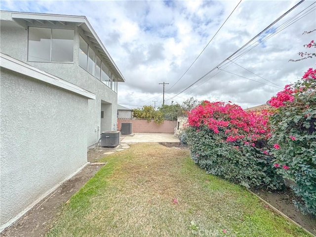 view of yard featuring central AC and a patio area