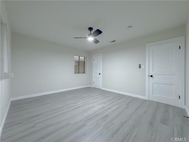 empty room with ceiling fan and light hardwood / wood-style flooring