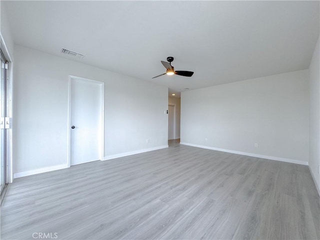 empty room with ceiling fan and light hardwood / wood-style floors