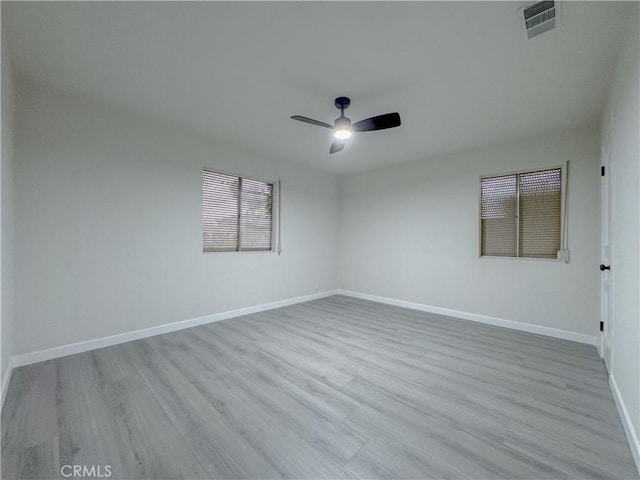 spare room with ceiling fan and light wood-type flooring