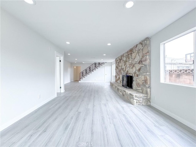 unfurnished living room featuring a fireplace and light wood-type flooring