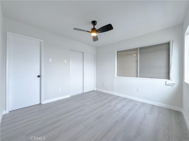 unfurnished bedroom featuring a closet, ceiling fan, and light wood-type flooring