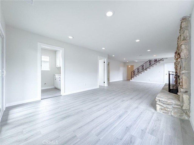 unfurnished living room featuring a fireplace and light hardwood / wood-style floors