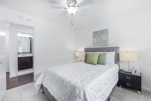 bedroom with sink, hardwood / wood-style flooring, ceiling fan, and ensuite bathroom