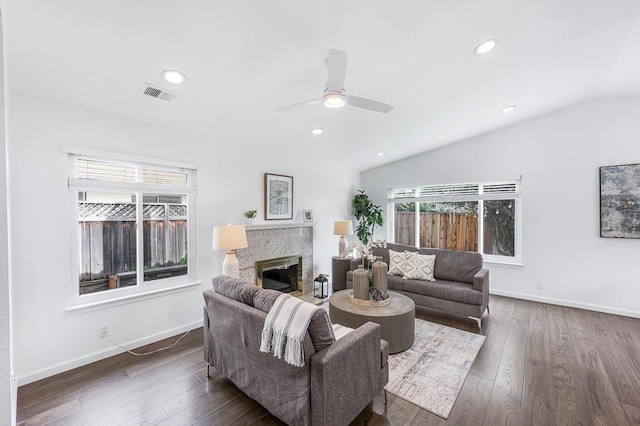 living room featuring ceiling fan, dark hardwood / wood-style floors, and vaulted ceiling