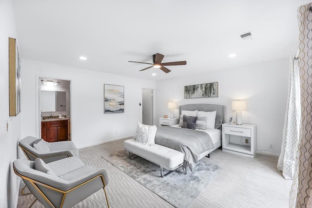 bedroom with sink, light carpet, ceiling fan, and ensuite bath