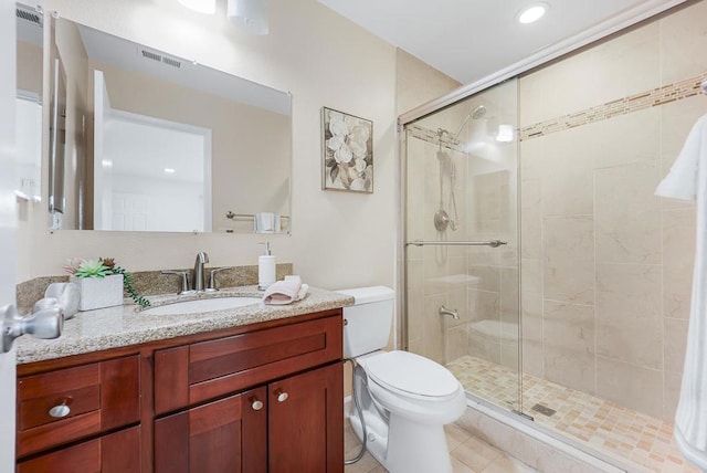 bathroom with tile patterned flooring, toilet, vanity, and walk in shower