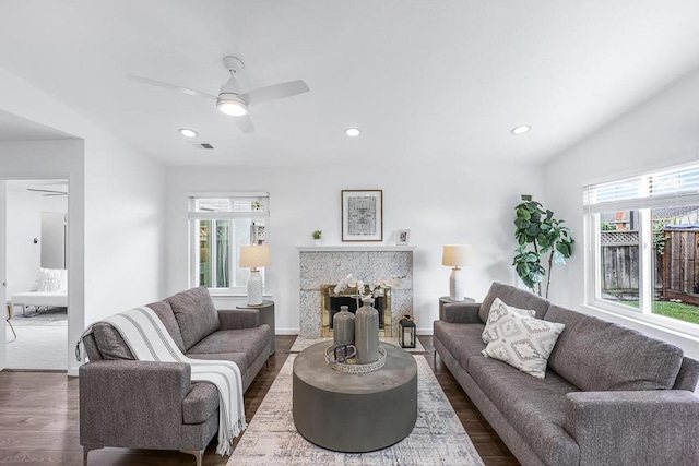 living room featuring ceiling fan and dark hardwood / wood-style floors