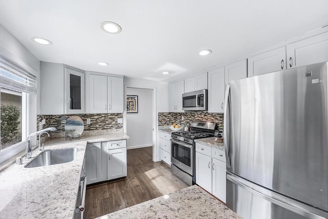 kitchen featuring sink, light stone countertops, and appliances with stainless steel finishes