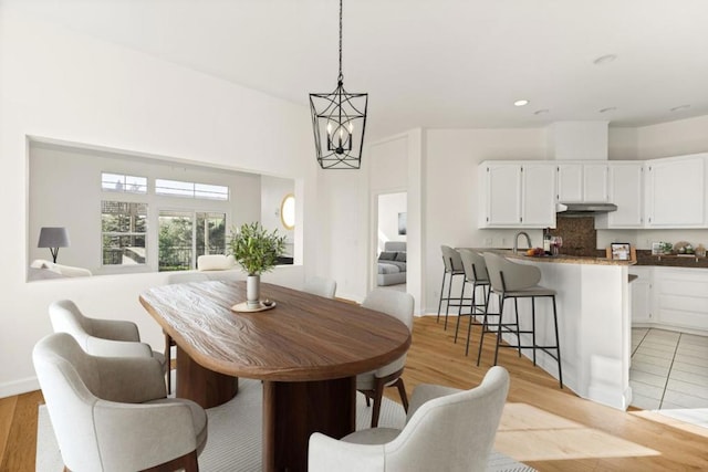 dining room featuring a notable chandelier and light wood-type flooring