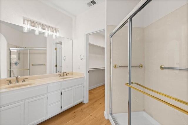 bathroom featuring vanity, wood-type flooring, and walk in shower