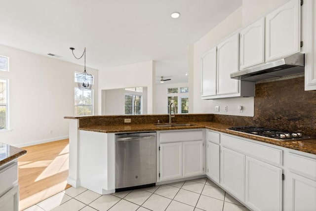 kitchen featuring appliances with stainless steel finishes, pendant lighting, sink, white cabinets, and dark stone counters