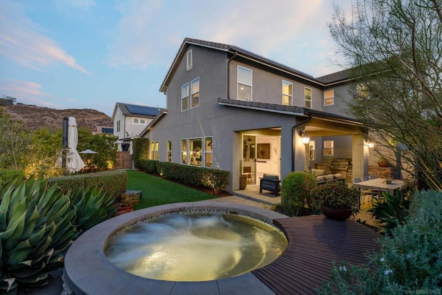 back of house with outdoor lounge area, a yard, and a mountain view